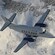 A turboprop aircraft flies over a snow covered mountain landscape